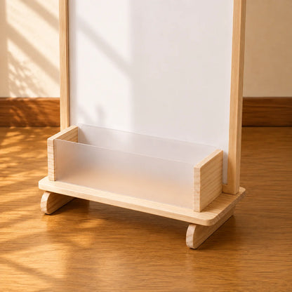 A wooden toy storage organizer with a gray pegboard back and a frosted clear plastic tray, shown on a wooden floor.