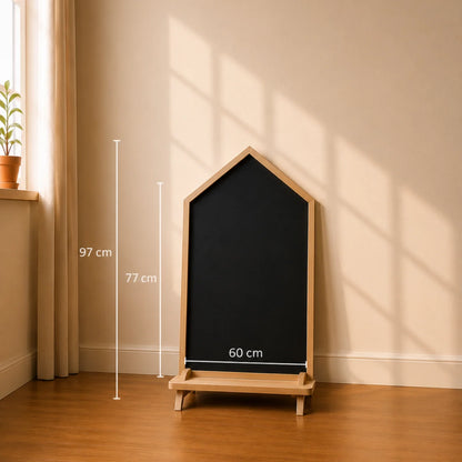 Close-up of a freestanding blackboard easel with a natural oak wood frame and base, set on a light wood floor with warm sunlight casting window-pane shadows.