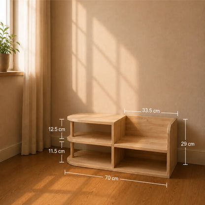 A light natural wood two-tier side table with curved legs, shown in a warm, sunlit room with dimension lines indicating its measurements (70 cm width, 29 cm height, 33.5 cm depth, and compartment heights of 12.