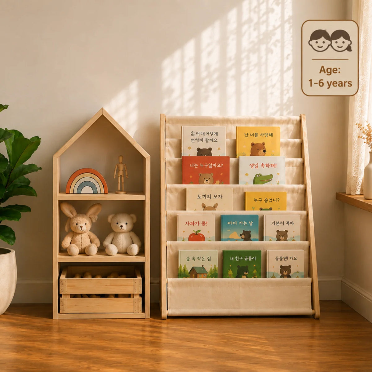 A styled children's room corner with a wooden house-shaped bookshelf and a fabric book rack filled with children's books, placed on a woven rug beside a bed and window.