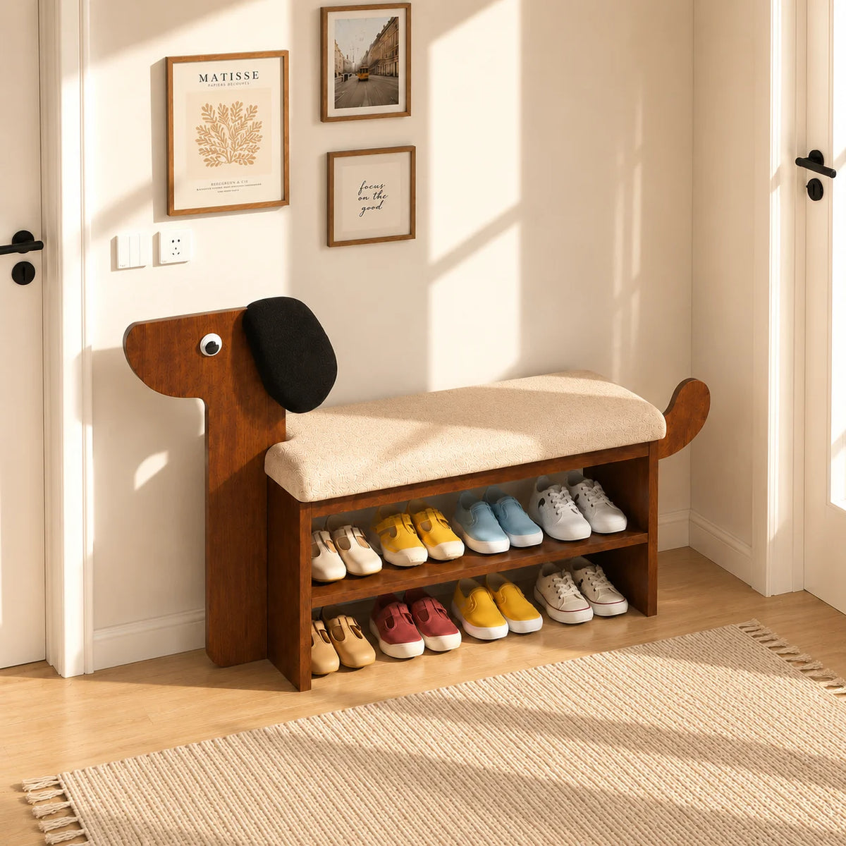 A wooden entryway bench with a dog-shaped head and tail, upholstered in beige fabric, holding multiple pairs of shoes on two lower shelves. The bench is placed in a sunlit room with a woven rug, framed wall art, and light wood flooring.